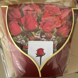 Macro view of a 3D pop-up greeting card featuring a bouquet of red roses in clear packaging