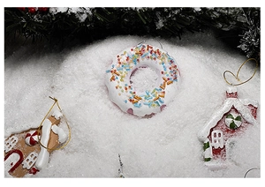 Detailed view of resin Christmas ornaments with glitter coating on a snowy background