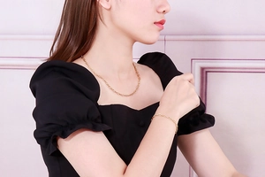 Golden titanium steel chain necklace and bracelet set with hammered texture worn by a model