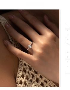 Macro shot of marquise cut moissanite ring with pavé setting on a model finger