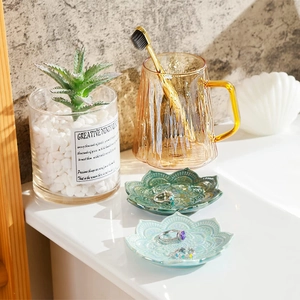 Detailed view of lotus ceramic trinket trays in green and light blue for jewelry storage
