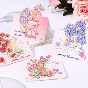 Artistic flower cards with lily of the valley and tulip designs on white desk