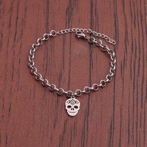 Minimalist silver stainless steel skull charm bracelet with ring chain on wood background