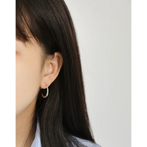 Minimalist S925 sterling silver O-shaped hoop earring worn by a model on clean white background