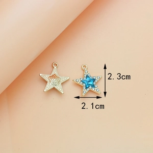 Detailed view of blue star pendant with gold metal base and white crystal accents