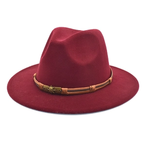Detail of burgundy wool fedora with a braided brown band and vintage skull metal badge