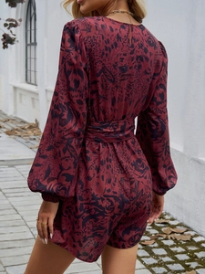 Vista posteriore di una tutina bordeaux a fiori con maniche a lanterna e vita alta con cintura