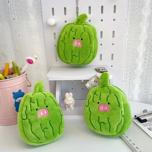 Three plush watermelon pig coin purses displayed on a desk with cute office accessories