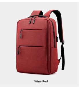 Detail view of wine red business backpack with USB charging port and textured fabric