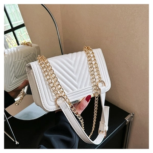 Close-up of white quilted leather bag with V-shaped stitching and gold chain strap