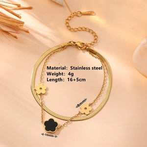 Gold double-layered stainless steel bracelet with black clover charms in a cozy setting