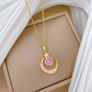 Halskette mit Mond und rosa Stern mit Kristallen in einer beigen Schmuckschatulle