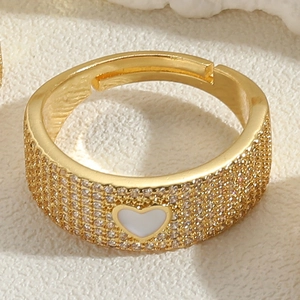 Macro detail of 14K gold plated open ring featuring micro zircon and white heart inlay