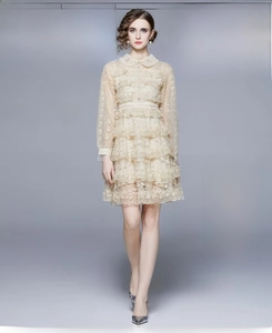 Détail de la robe élégante en dentelle champagne avec broderie florale et jupe à volants
