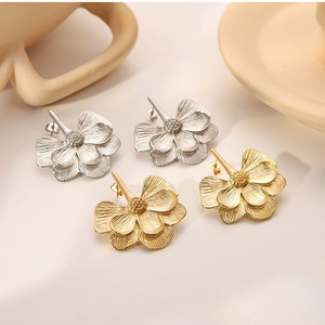 Detail of 18k gold and silver floral earrings featuring delicate petal textures