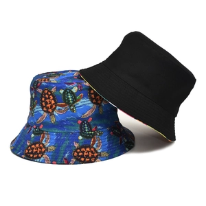 Double-sided reversible bucket hat with turtle print and classic black cotton design