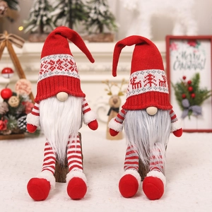 Close-up of two Christmas gnomes with knitted hats and faux fur on a white surface