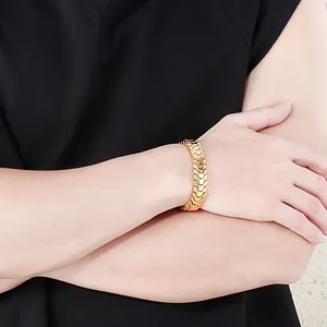 Detailed close-up of golden dragon bone chain link bracelet on male wrist in punk style