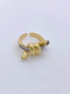 Macro detail of golden knot ring with micro-pave cubic zirconia and adjustable band