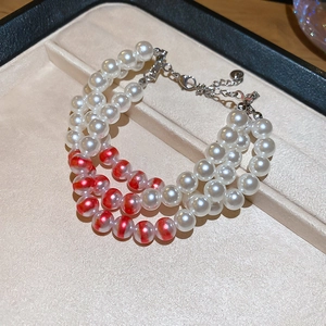 Detailed shot of triple-layer pearl and patterned bead bracelet in a velvet jewelry tray