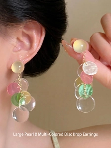 Macro shot of colorful acrylic petal drop earrings with gold chains and sheer finish