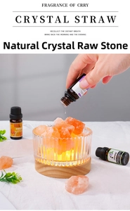 Adding essential oil to natural orange crystal salt stones in a glass bowl with wood base