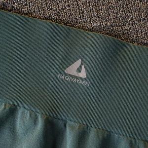 Détail du short de yoga côtelé à taille haute en vert foncé avec logo NAQIYAYABEI
