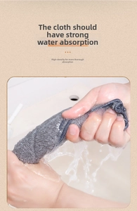 Close-up of hands wringing a thick grey microfiber cleaning cloth to show water absorption