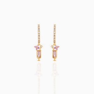 Close-up of gold earrings with pink rectangular stones and purple zircon flowers