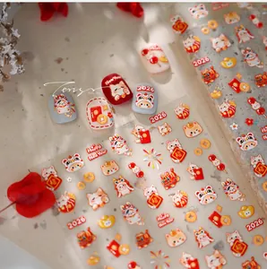 Macro detail of 2026 Lunar New Year nail stickers featuring red lucky cats and gold patterns