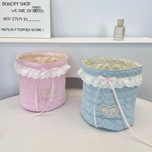 Detail of heart quilted desktop storage baskets with delicate lace trim and ribbon bows