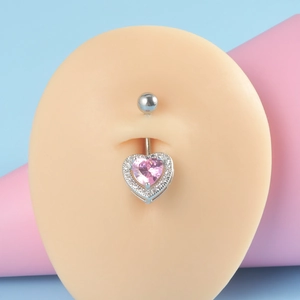 Detail of a silver heart-shaped navel ring with pink zircon on a silicone model
