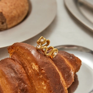 Bague vague dorée avec zircons clairs posée sur un croissant pour un style créatif chic