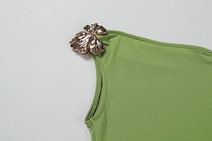 Macro shot of olive green dress featuring 3D hammered gold metal leaf shoulder detail