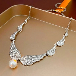 Silver winged earrings with micro-inlaid diamonds and a white drop pearl pendant