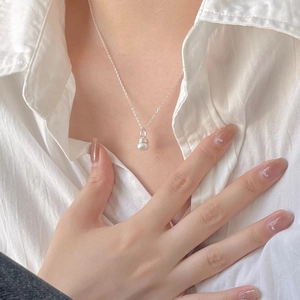 Close-up of a minimalist 925 sterling silver pearl necklace on model's neck