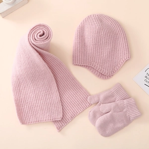 Detailed view of soft pink knitted baby winter set including hat, scarf and mittens