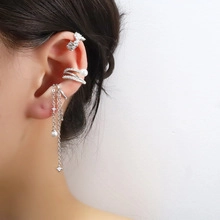 Detailed view of silver snake wrap ear cuffs with pearls and zircon stones on model