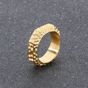 Detailed close-up of a wide hammered texture stainless steel ring in gold finish