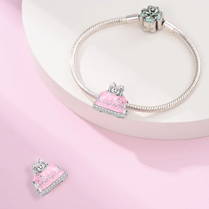 Detailed macro of pink enamel handbag charms on a silver snake chain bracelet