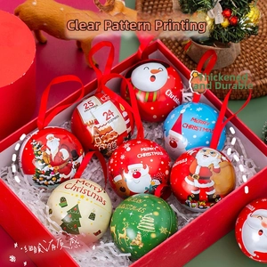 Macro view of Christmas tinplate ball ornaments featuring festive patterns and red ribbons