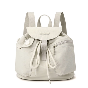 Close-up of nylon backpack with drawstring closure, zipper pocket and silver buckle detail