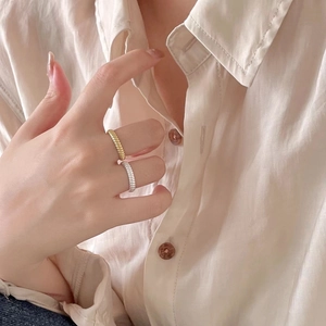 Close-up of gold and silver spiral twist rings worn on hand for a chic French style