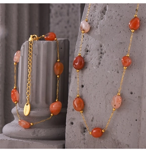 Macro detail of natural orange agate beads and gold stainless steel jewelry set texture