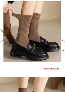 Gros plan de chaussettes brunes portées avec des mocassins en cuir noir élégants