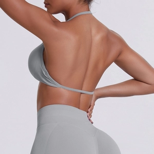 Detail of seamless ribbed gray sports bra with halter open back and high waist leggings