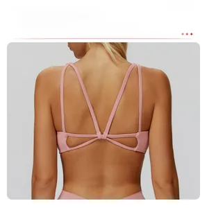 Detail of cross-strap back design on a dusty pink professional yoga sports bra