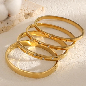 Set of four gold stainless steel bangles with sparkling zircon accents and a minimalist finish