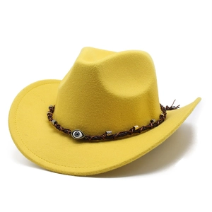 Detail of yellow felt cowboy hat with braided cord and evil eye charm decoration