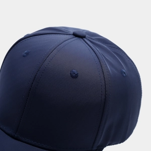 Dettaglio macro del berretto blu navy con cuciture a 6 pannelli e occhielli ricamati